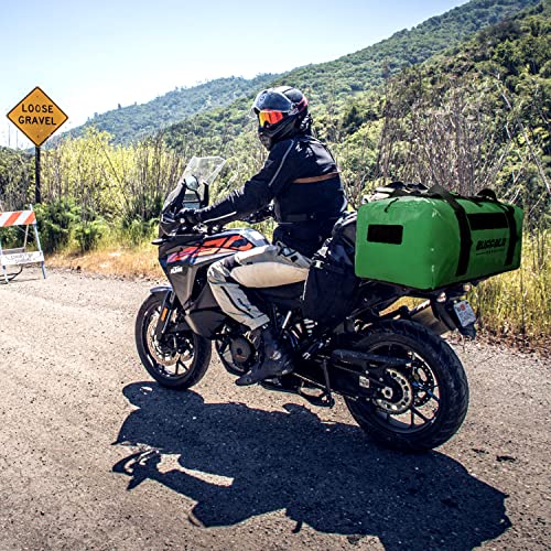 Person on a motorcycle with a green bag in a mountainous area