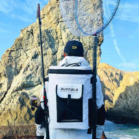 Person fishing with a backpack labeled 'Buffalo' against a rocky coastal background