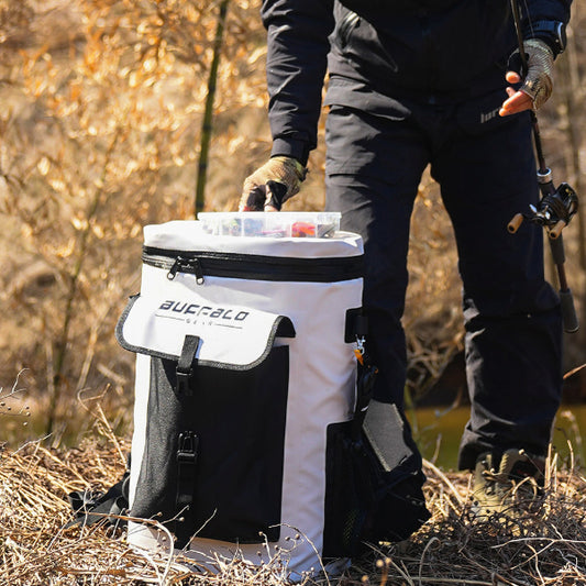 Person holding a white cooler with 'Buffalo' branding in a forest setting