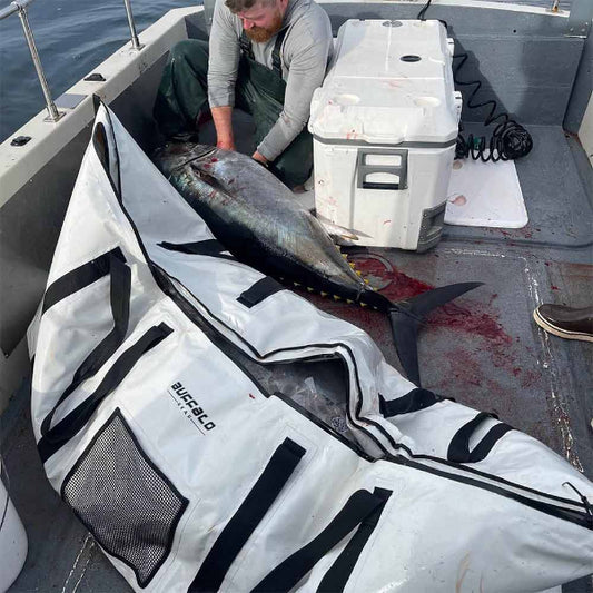 Man on a boat with a large fish draped over a branded mat.