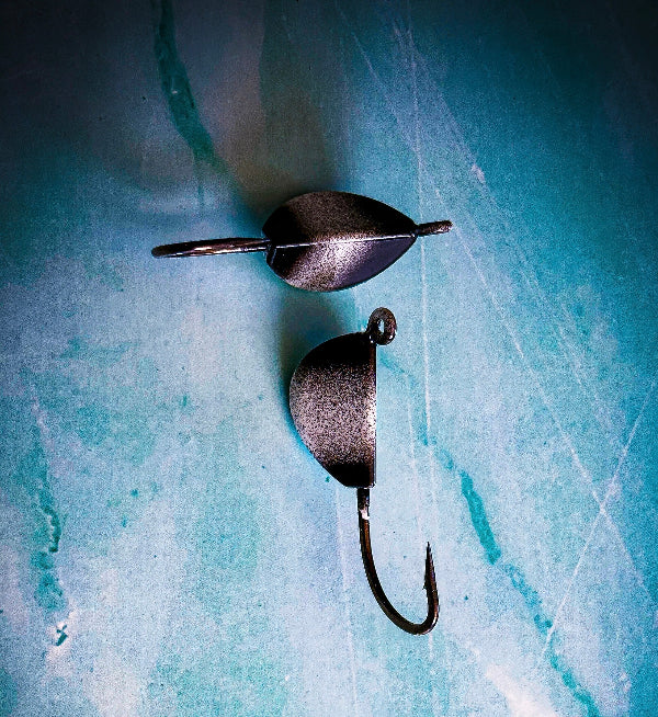 Two fishing lures on a textured blue surface