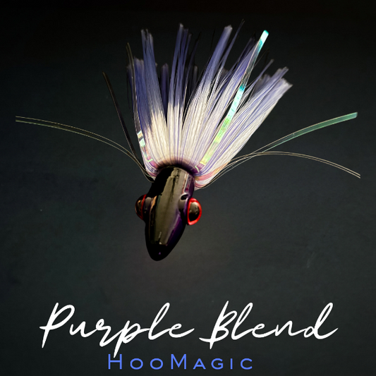 Fishing lure with colorful fibers on a dark background, labeled 'Purple Blend HooMagic'.