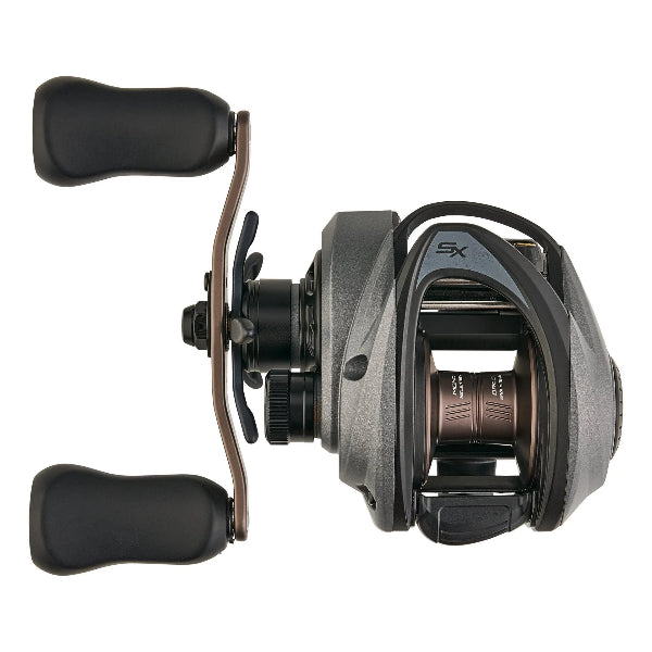Dark grey low-profile fishing reel with bronze handle and prominent SX logo.
