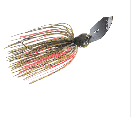 A fishing jig lure with a dark metal blade, a textured olive-brown head, and skirt strands in tan, black, and pink on a plain white background.