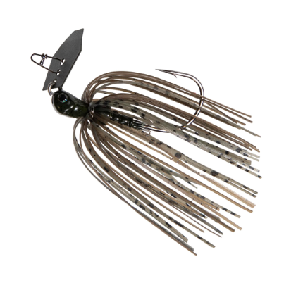 A fishing jig lure with a dark metal blade, hook, and wire frame, featuring a translucent skirt with a brown, beige, and black camouflage pattern, isolated on a white background.