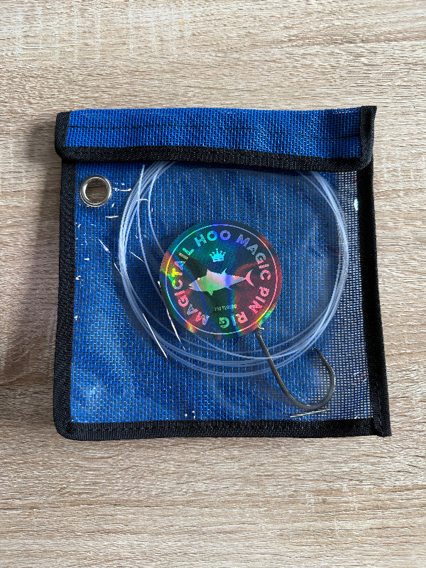 Blue pouch with a rainbow-colored 'Hoo Magic Pin' on a wooden surface