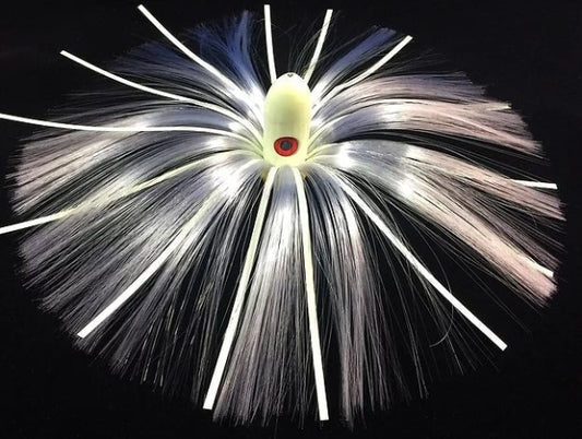 Fishing lure with white and black fibers on a black background