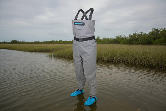 Gray waterproof waders with blue booties and black suspenders.