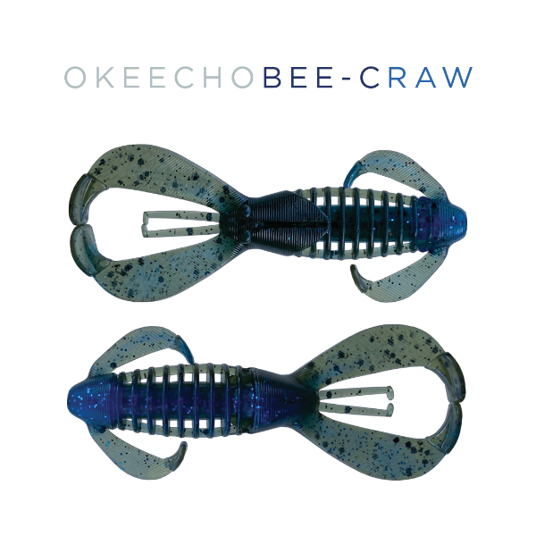 Two blue and black Okeecho Bee-Craw fishing lures on a white background