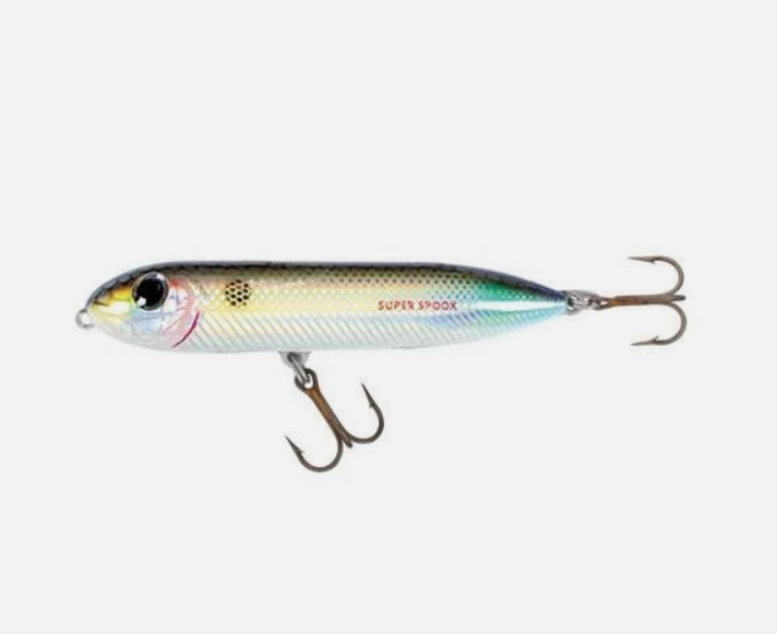 A shiny silver, green, and gold Heddon Super Spook fishing lure with two treble hooks.