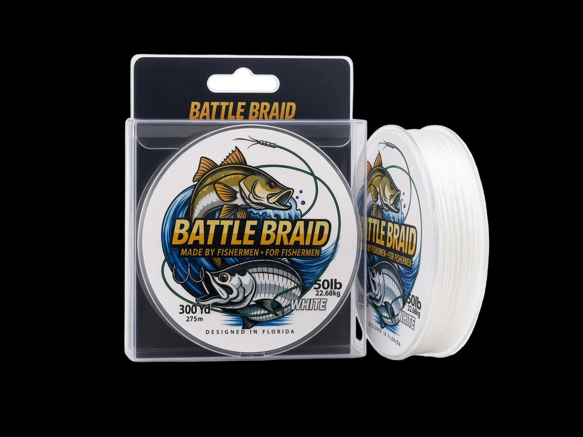 Battle Braid fishing line shown in its retail packaging, with a spool of white line standing beside the clear plastic box. The packaging features a large fish graphic and the text 'BATTLE BRAID' and '50lb'.