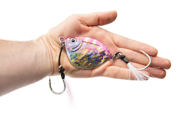 Hand holding a colorful fishing lure against a white background
