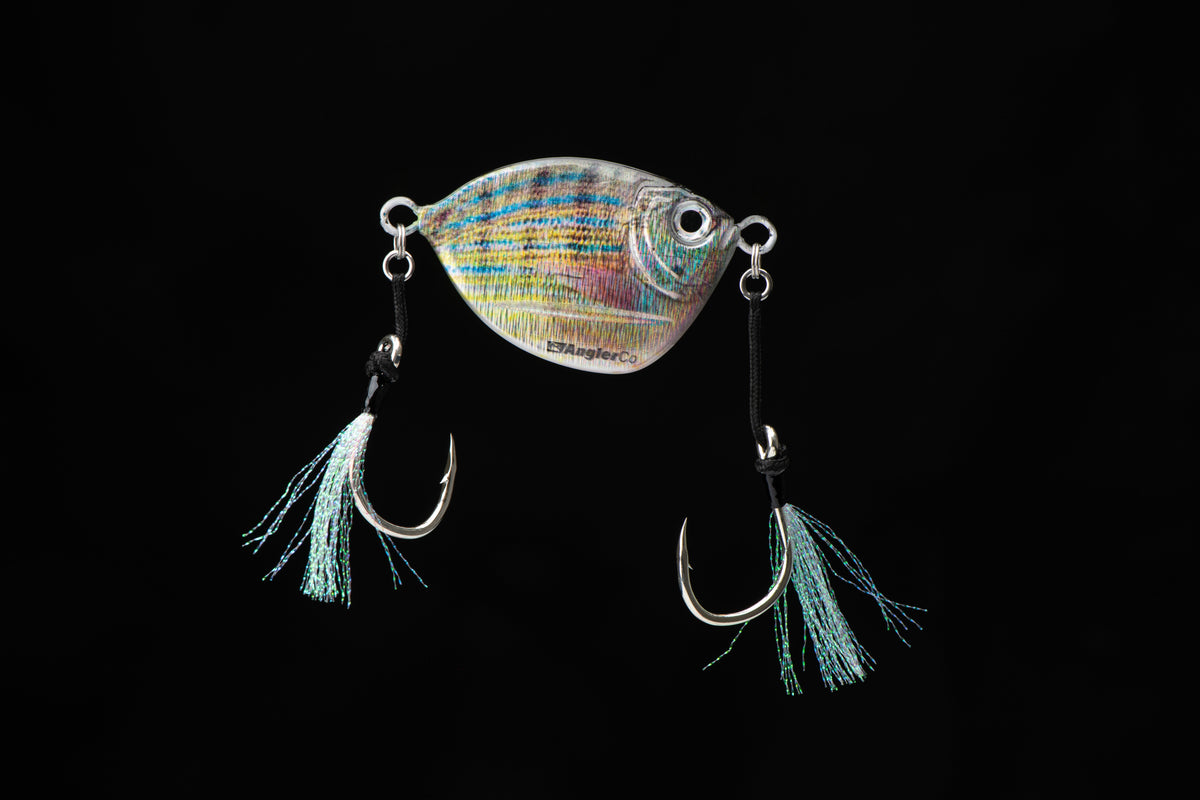 Fishing lure with a colorful body and blue tassels on a black background