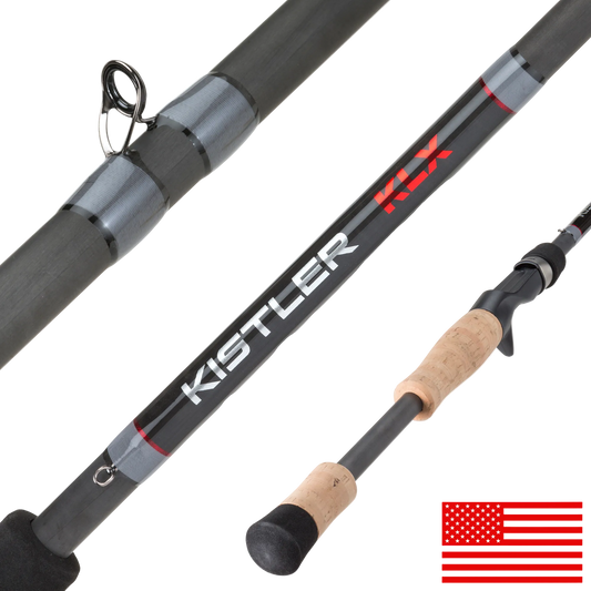 A close-up of a Kistler FX fishing rod showing the black and gray carbon fiber shaft with red and white branding, a cork-wrapped handle, line guide, and butt cap, on a white background with a small US flag graphic in the corner.