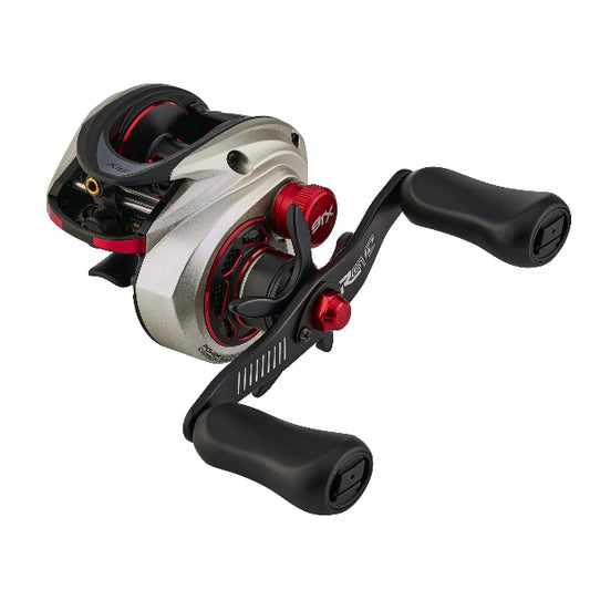 Silver and black low profile fishing reel with red accents.