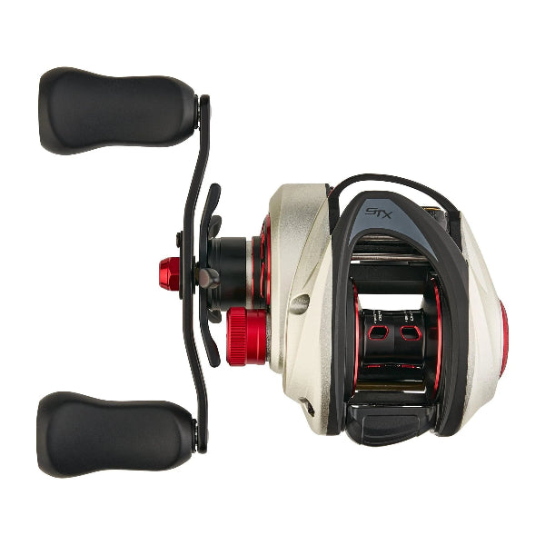Silver and black low profile fishing reel with STX logo and red accents.