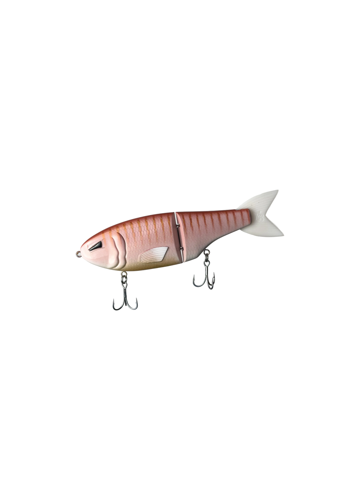 A soft plastic fishing lure shaped like a small fish, shown on a plain white background. The lure has a pinkish-orange top with darker vertical stripes, a white belly, a white tail, and two metal treble hooks hanging below.