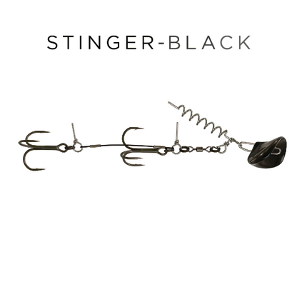A fishing lure labeled 'STINGER-BLACK' on a plain white background. The lure has three dark treble hooks connected by a wire frame with a coiled spring and a black weighted tail.