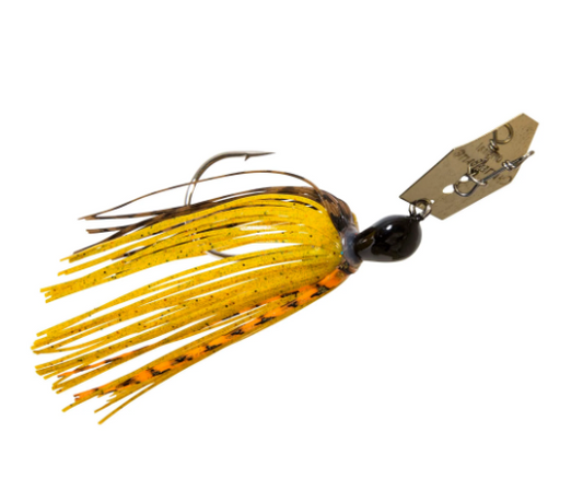 A fishing jig lure with a metallic gold and black skirt, a black bead head, and a gold-colored metal blade attached with a spring loop, shown against a plain white background.
