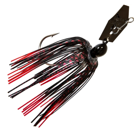 A fishing jig lure with a black and red skirt, a metal blade, and a treble hook, isolated on a white background.