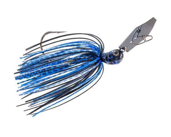 A fishing jig lure with a metallic silver blade, a blue and black patterned head, and a skirt made of black and blue strands, shown on a plain white background.