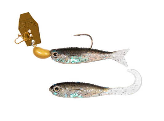 Two soft plastic fishing lures shaped like small fish, shown on a plain white background. One lure has a gold jig head and a silver-blue speckled body, while the other is mostly clear and translucent with a silver-blue speckled body.