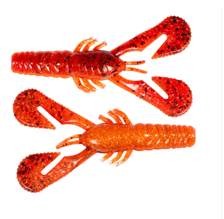 Two soft plastic crawfish lures in orange and red glitter colors with black speckles, shown on a plain white background.