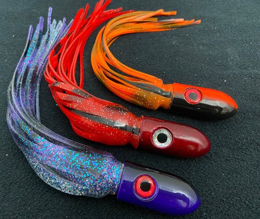 Three colorful fishing lures on a dark background