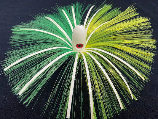 Fishing lure with green and white fibers on a dark background