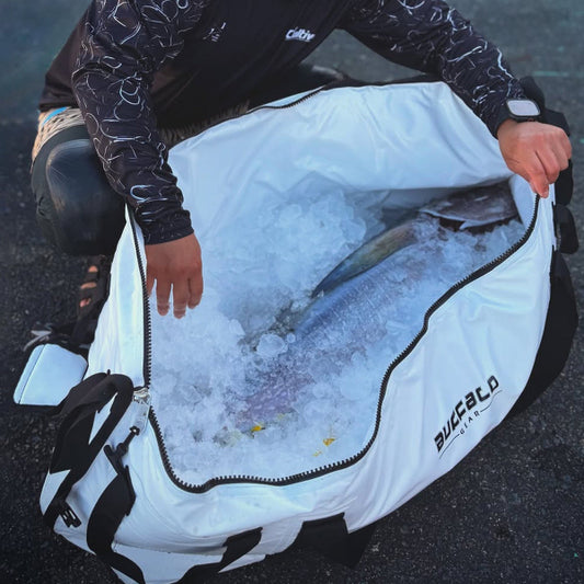 Person holding a large fish out of an ice-filled cooler bag with 'Buffalo' branding.