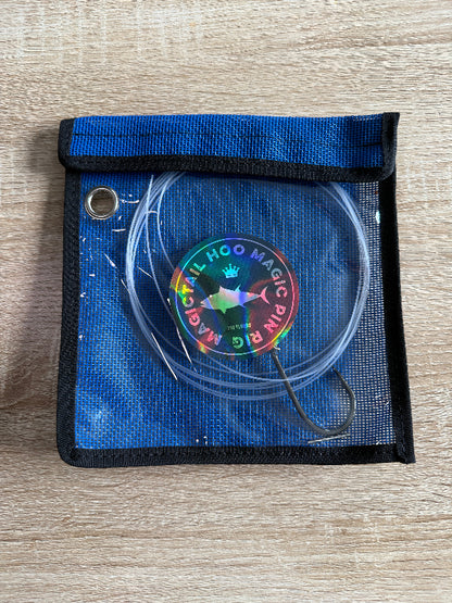 Blue pouch with a rainbow-colored 'Hoo Magic Pin' on a wooden surface